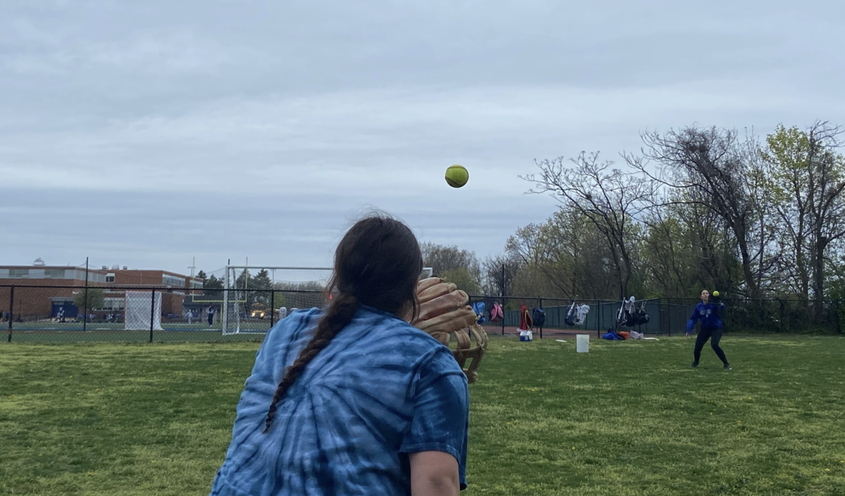 Varsity girls softball warms up before a game.